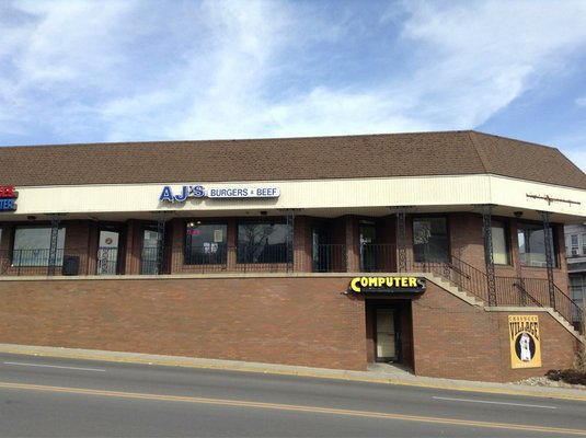 image of AJ's Burgers and Beef, a strip center location on a sloped street